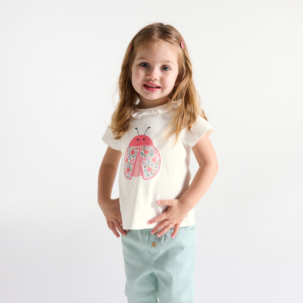 تيشيرت أبيض وبياقة مُكشكشة، مُزيَّن برسمة حشرة، للفتيات الصغيرات